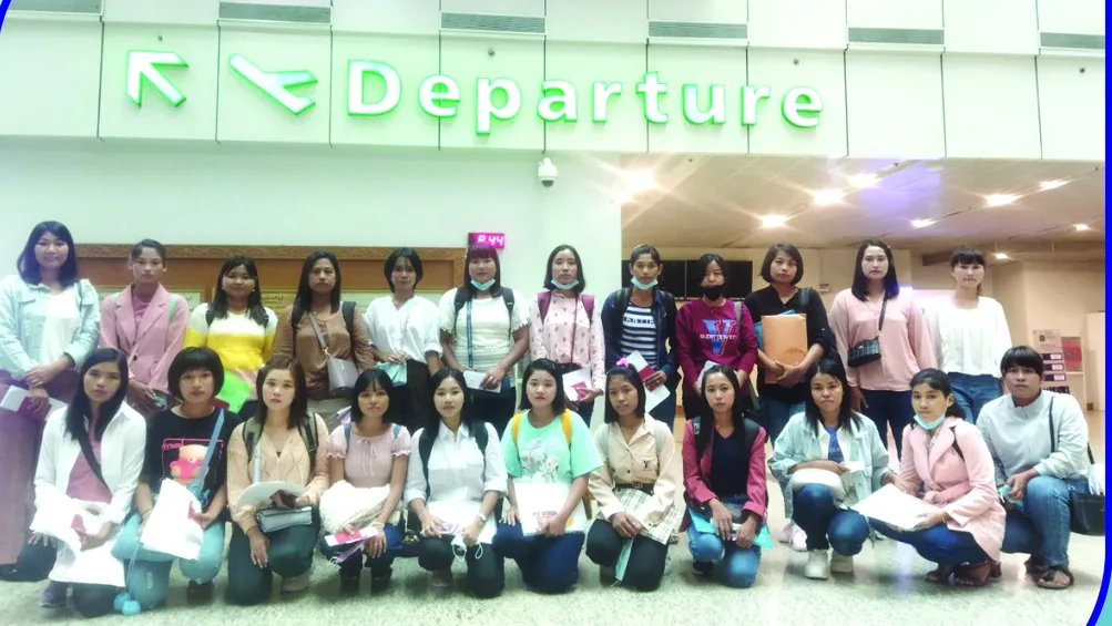 A large group of candidates gathered beneath a Departure sign in an airport terminal